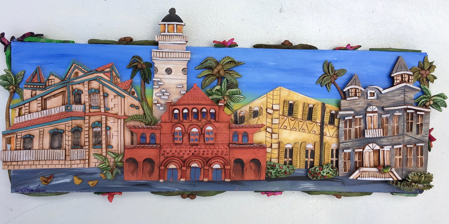 Polymer relief of Key West landmark buildings, the lighthouse and the Custom House among them, against a blue sky.